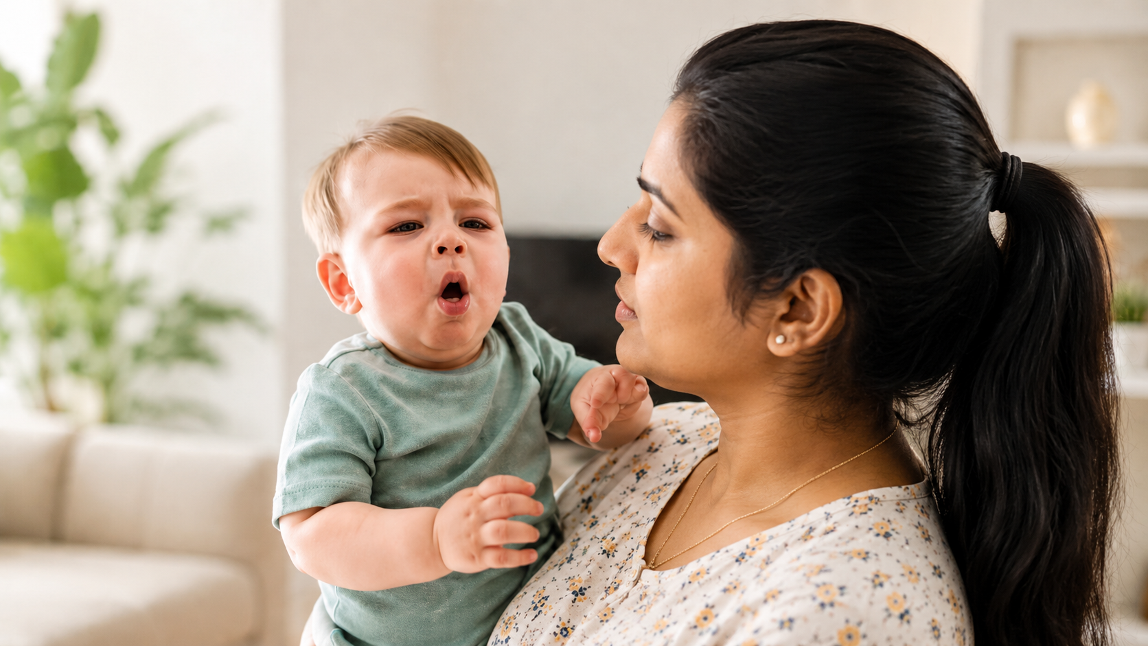 Indian mother holding an infant with severe coughing distress in a calm home-care setting